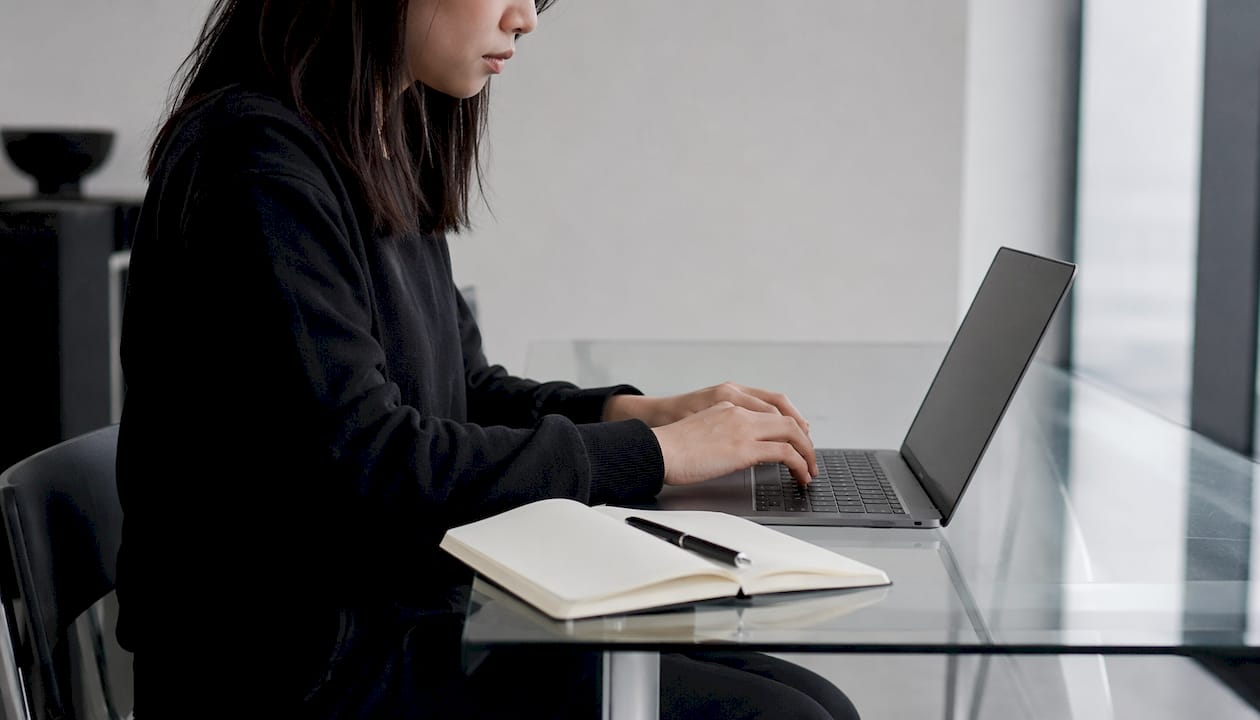 Degetele unui dezvoltator navighează cu pricepere tastatura laptopului, creând soluții pentru o lume mai accesibilă.