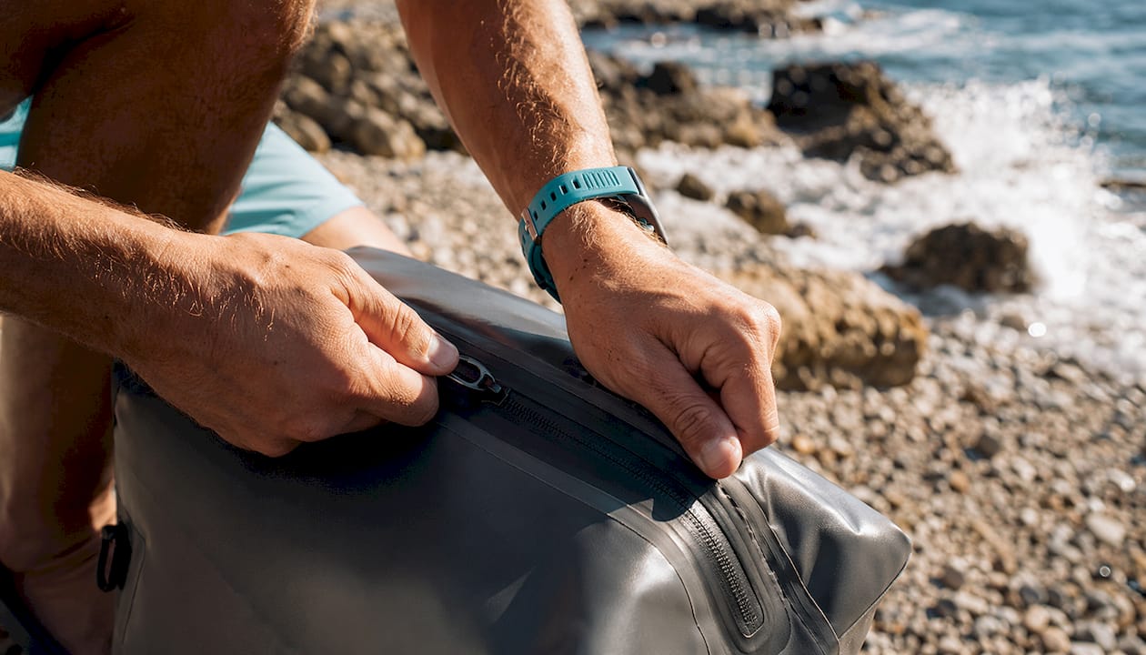 Close-up of hands sealing waterproof backpack zipper