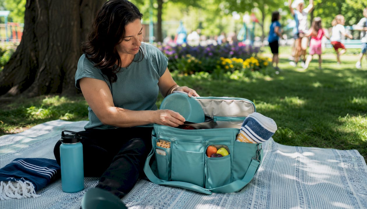 Hands organizing sports mom bag contents