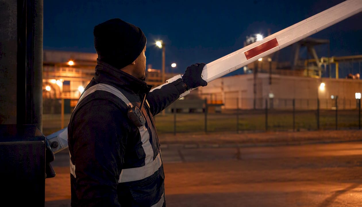 Security service contract terms: Australia's 2026 guide 8 Officer lowering gate barrier at dusk