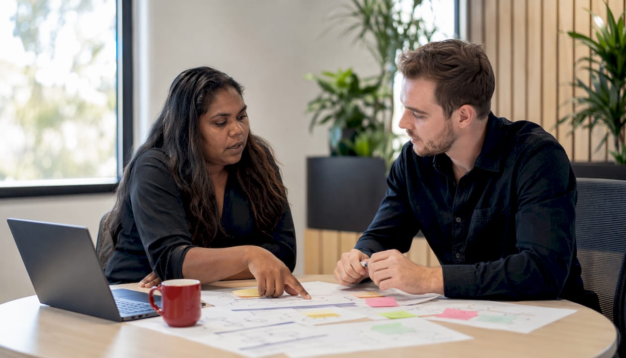 Essential 8 for Australian agencies: practical compliance guide 5 Two colleagues discussing cybersecurity implementation plan