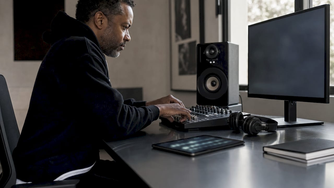 Man editing AI podcast audio in home office