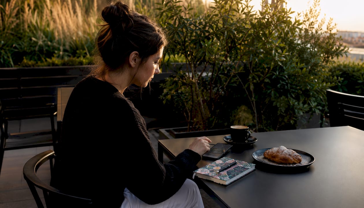 Hands holding smartphone at café table