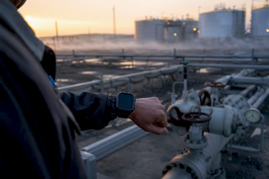 Hand holding rugged device near wellhead