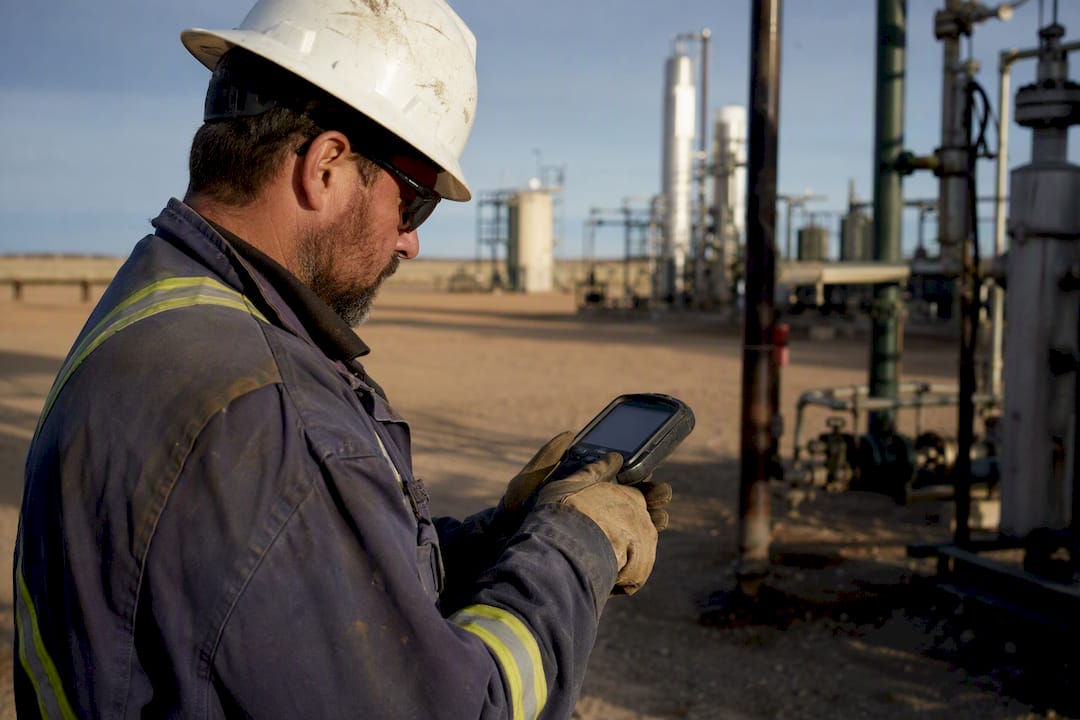 Technician manually logging maintenance data on handheld device