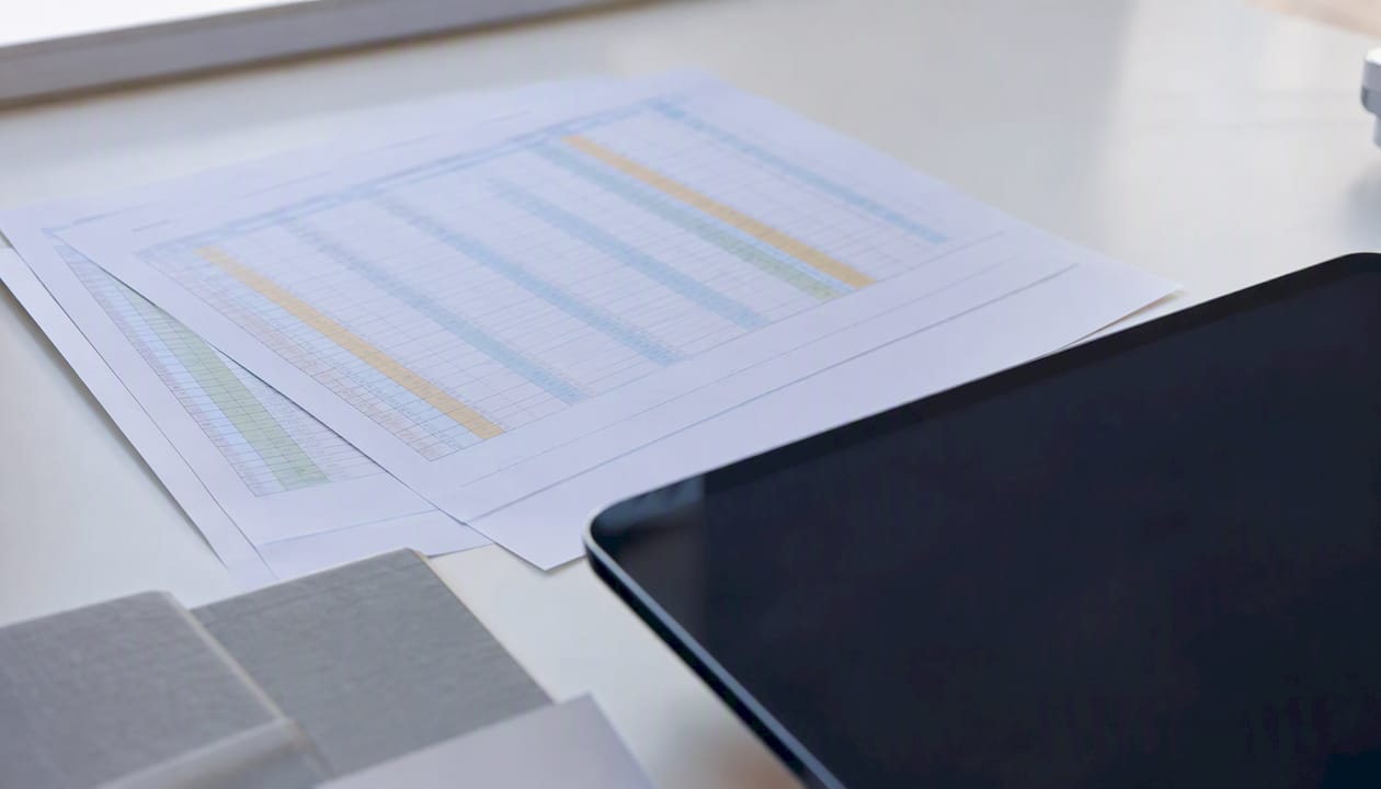 Blurred spreadsheet printouts with color highlights