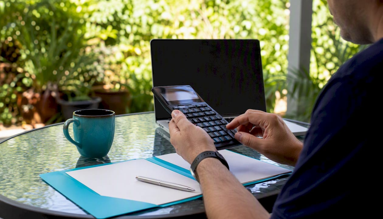 Hands calculating mortgage offset savings with calculator