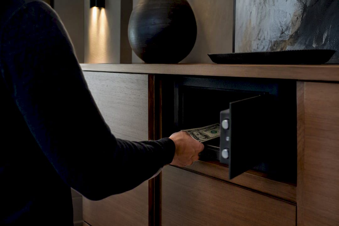 Hand opening home safe for emergency cash