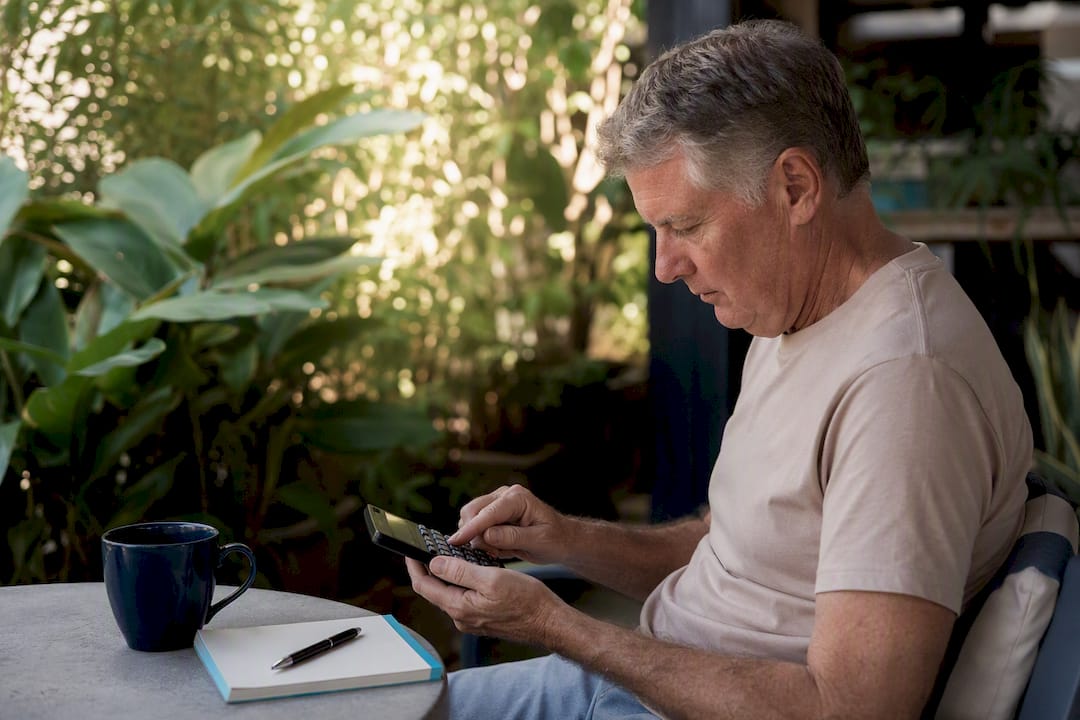 Retiree calculating super withdrawal tax at home
