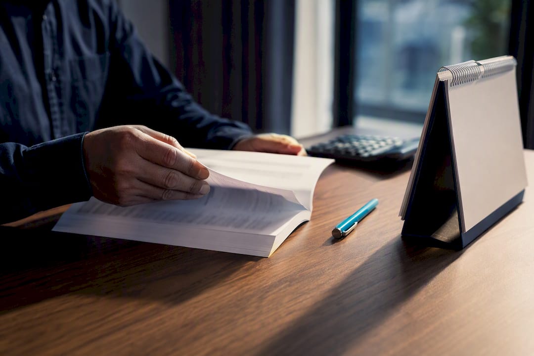 Hands reviewing an investment bond disclosure booklet