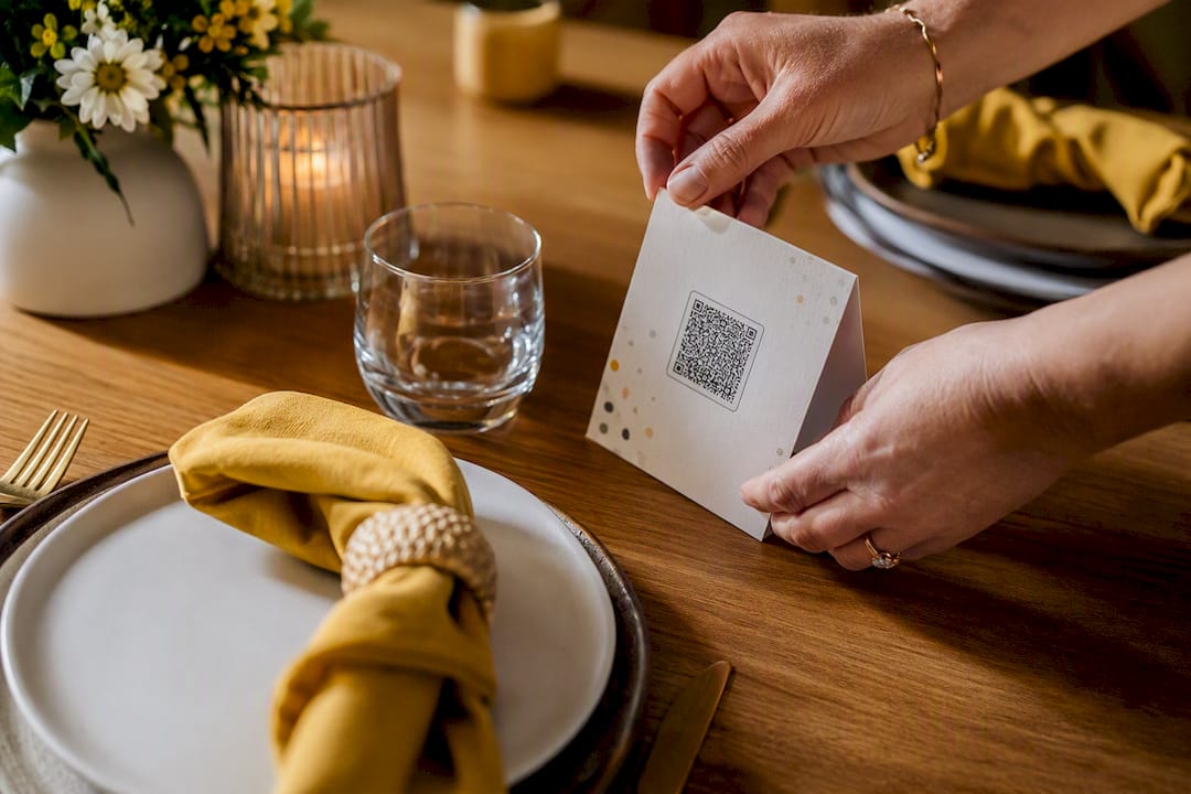 Hands arranging birthday QR table card