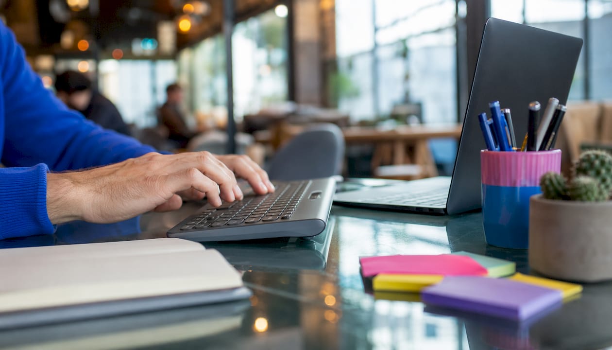 Hands typing on keyboard with SEO reports nearby