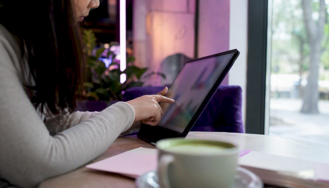 Hands interacting with tablet showing data charts