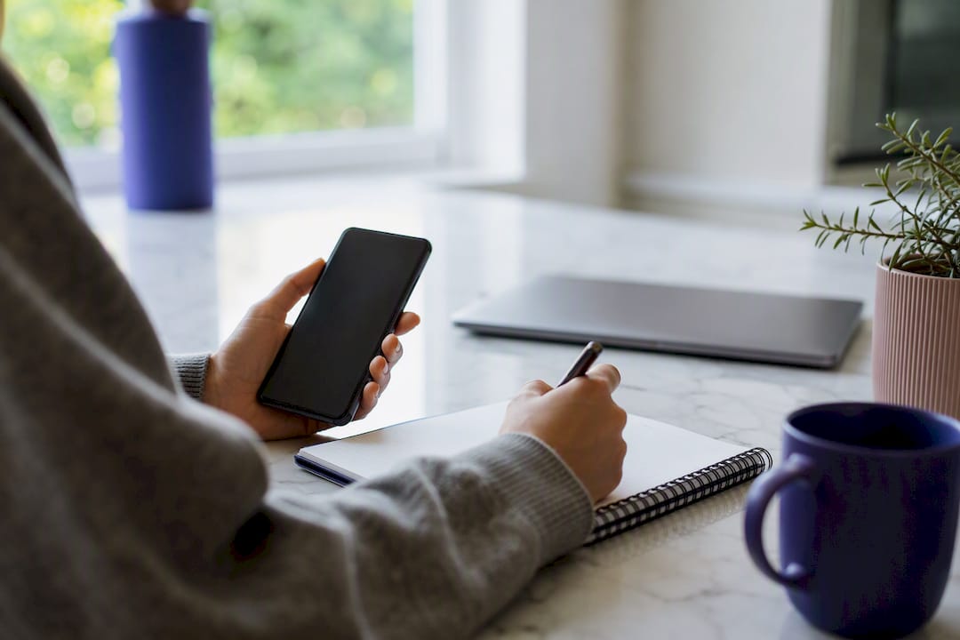 Hands checking unlinked brand mentions on smartphone