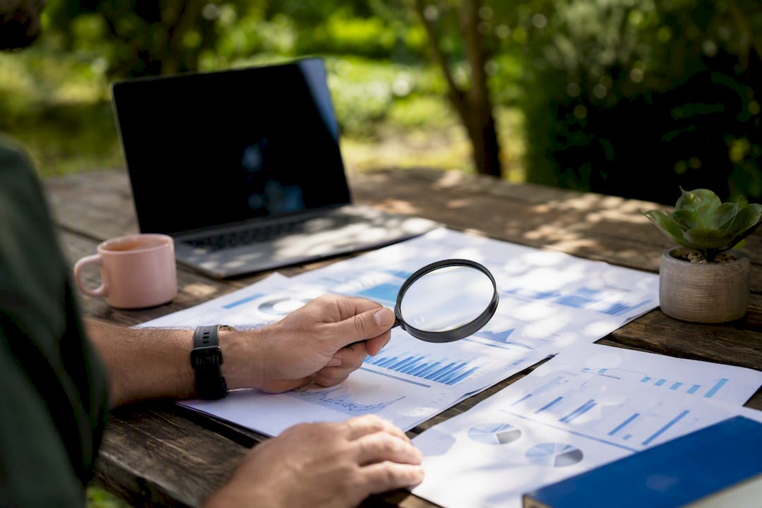 Hand examining backlink report with magnifier