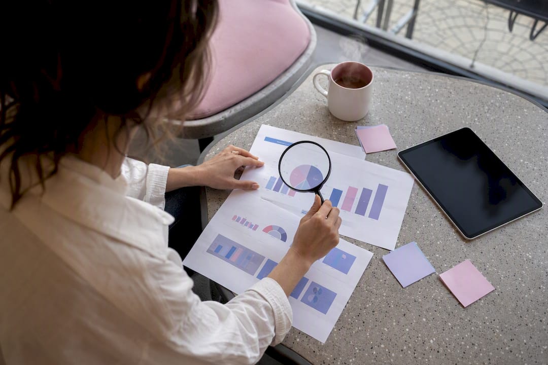 Hands examining keyword data with magnifying glass