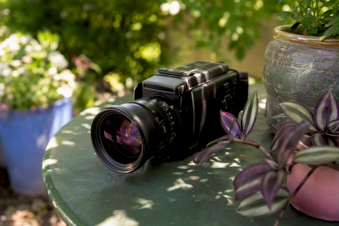 Video camera lens with film reel on wood table