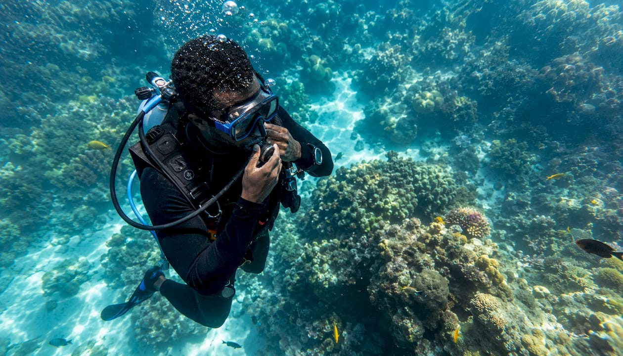 Scuba diver adjusting mouthpiece underwater