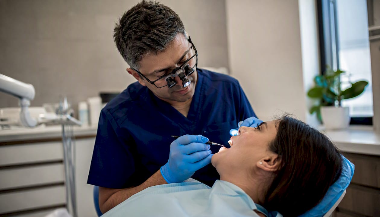 Dentist applying composite resin to chip