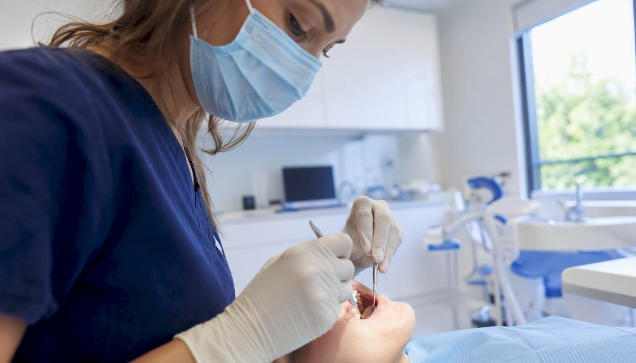 Dental hygienist performing deep cleaning inside mouth