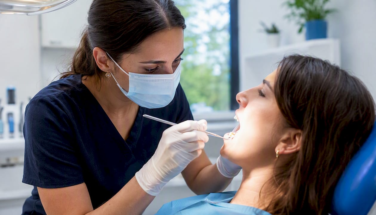 Close-up of dentist checking tooth with black spot