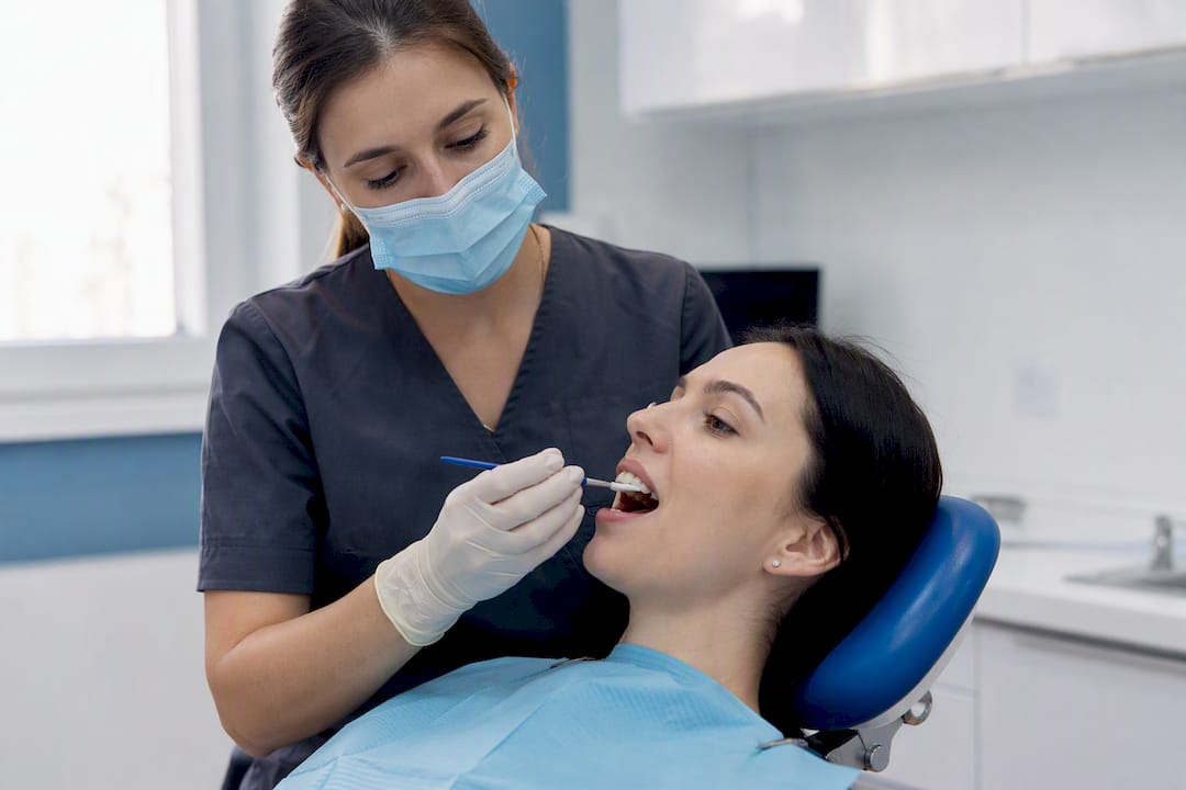 Dental hygienist applying fluoride varnish on teeth