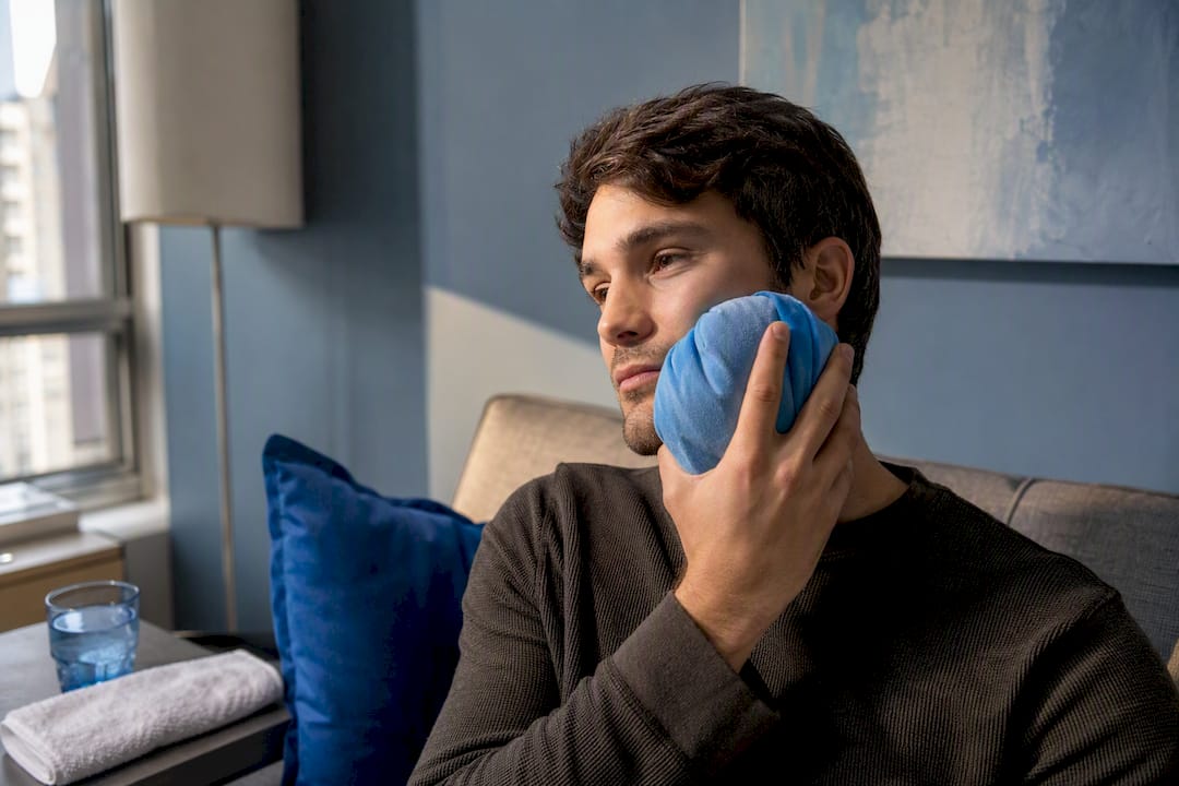Patient applying cold compress after extraction
