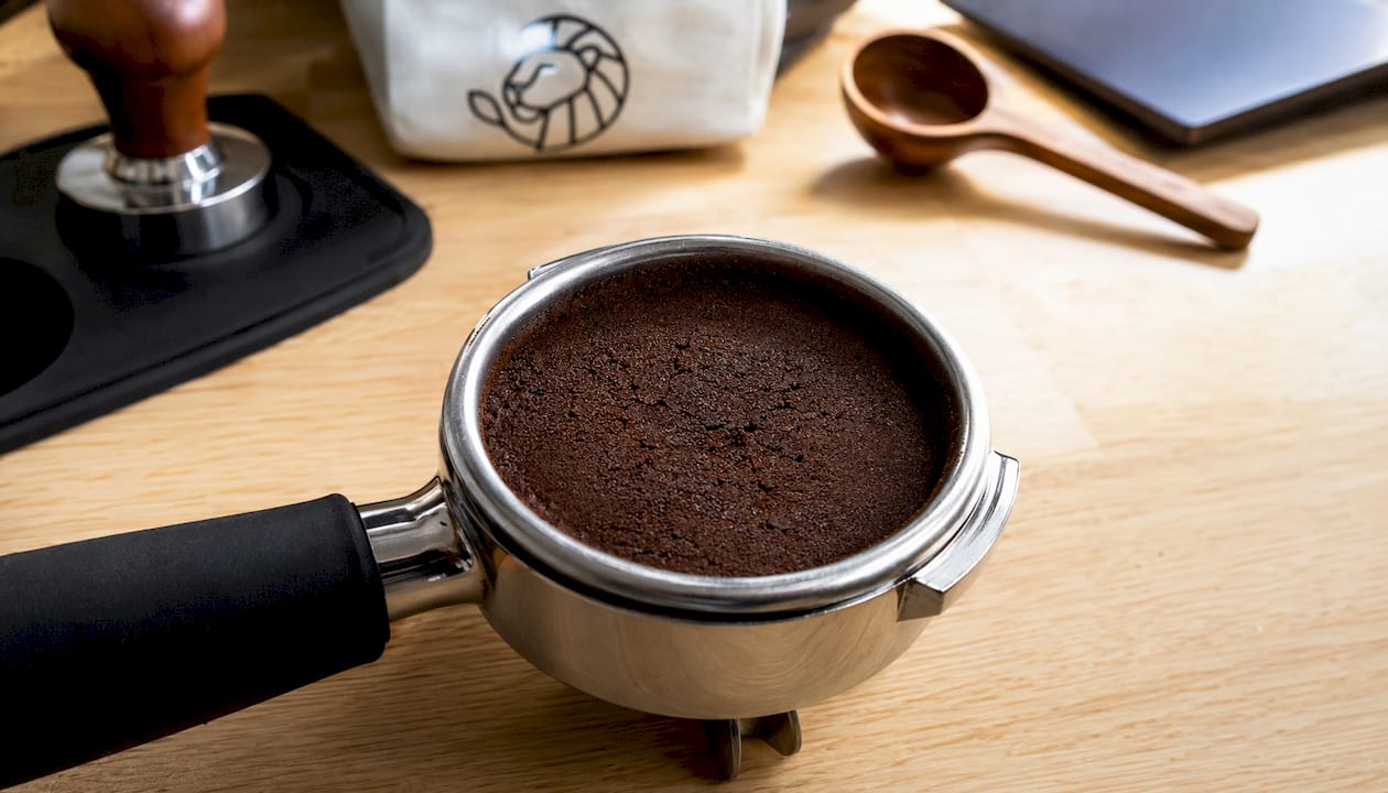 Close-up tamped espresso puck in portafilter
