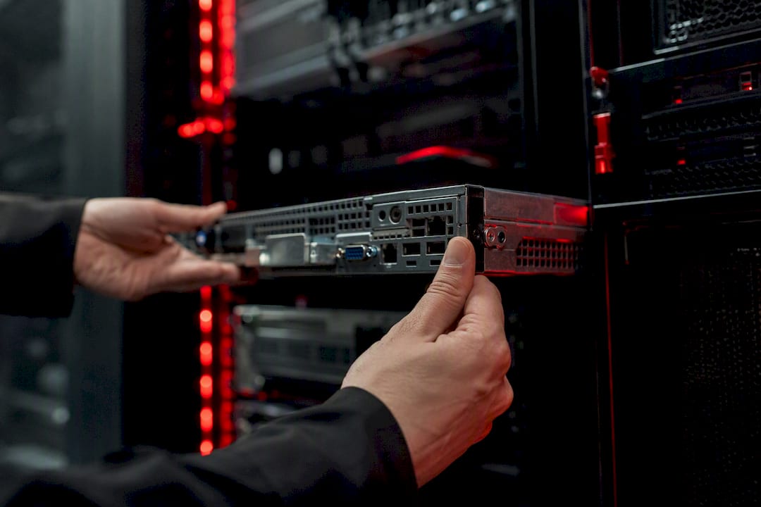 Hands sliding server into rack in data center