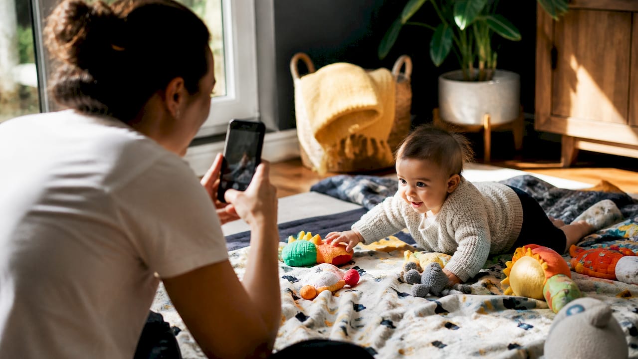 Parent filming baby milestone with phone