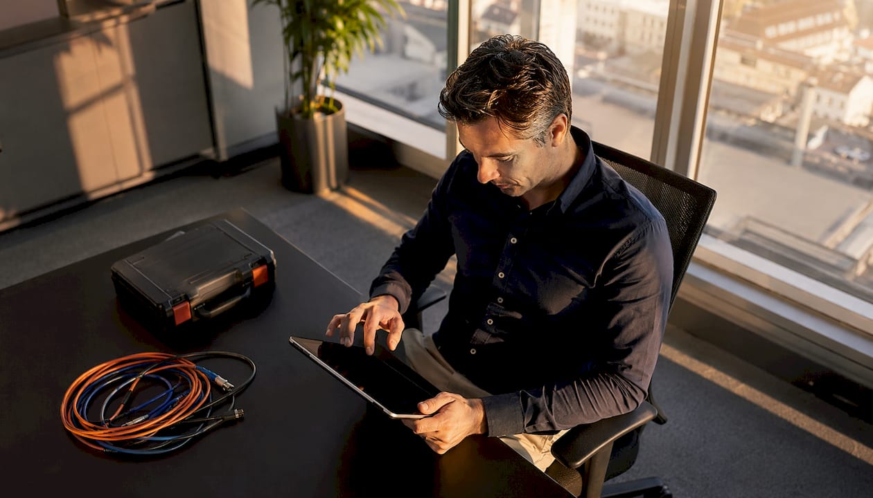 Een IT-specialist controleert de status van de servers op een tablet.