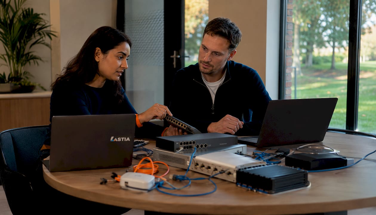 Twee IT-specialisten die ter plekke met elkaar over netwerkapparatuur praten.