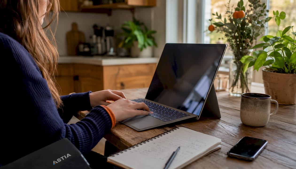 Iemand werkt op een laptop en gebruikt daarbij Microsoft Outlook.