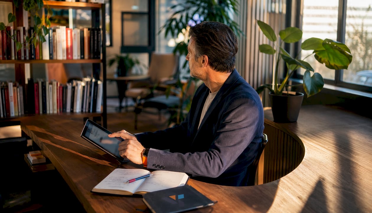 Ondernemer vergelijkt verschillende CRM-systemen op zijn tablet