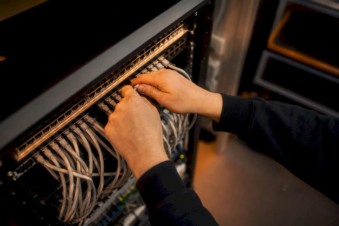 Handen die netwerkkabels aansluiten in de IT-ruimte op kantoor