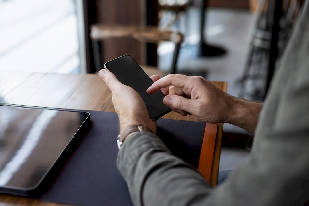 Handen die MFA instellen op een smartphone