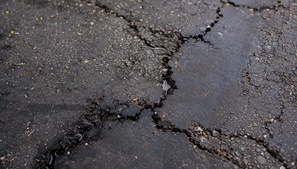 Close-up of hairline cracks in parking lot asphalt