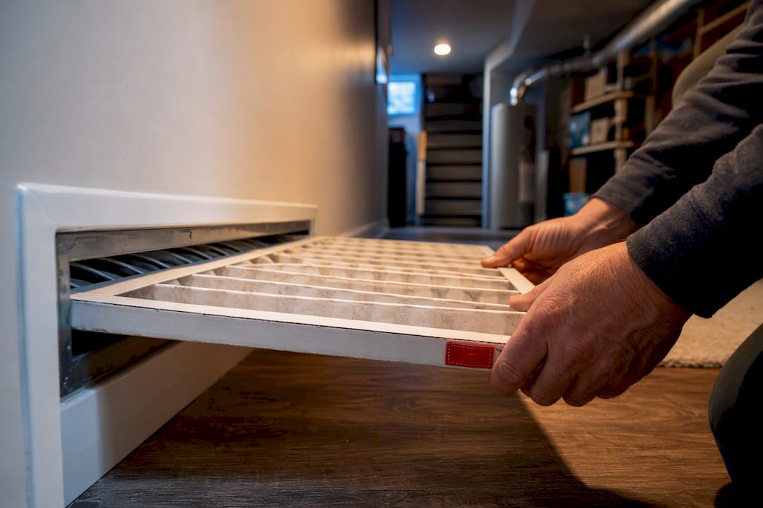 Homeowner checking furnace air filter