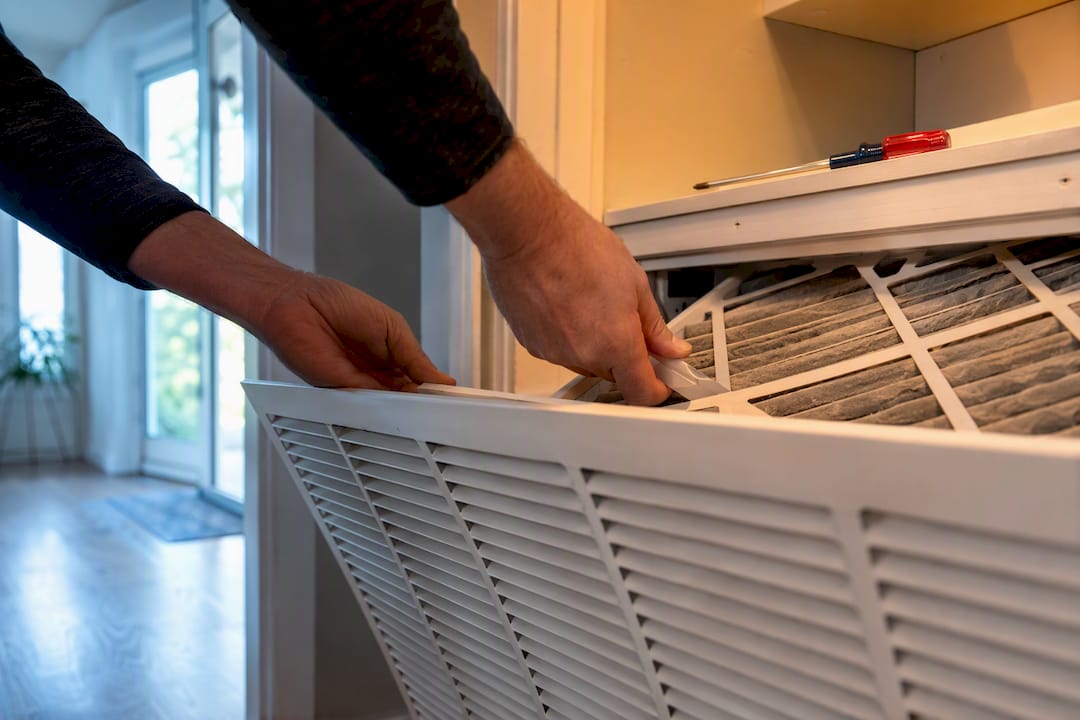 Homeowner checking a dusty HVAC air filter