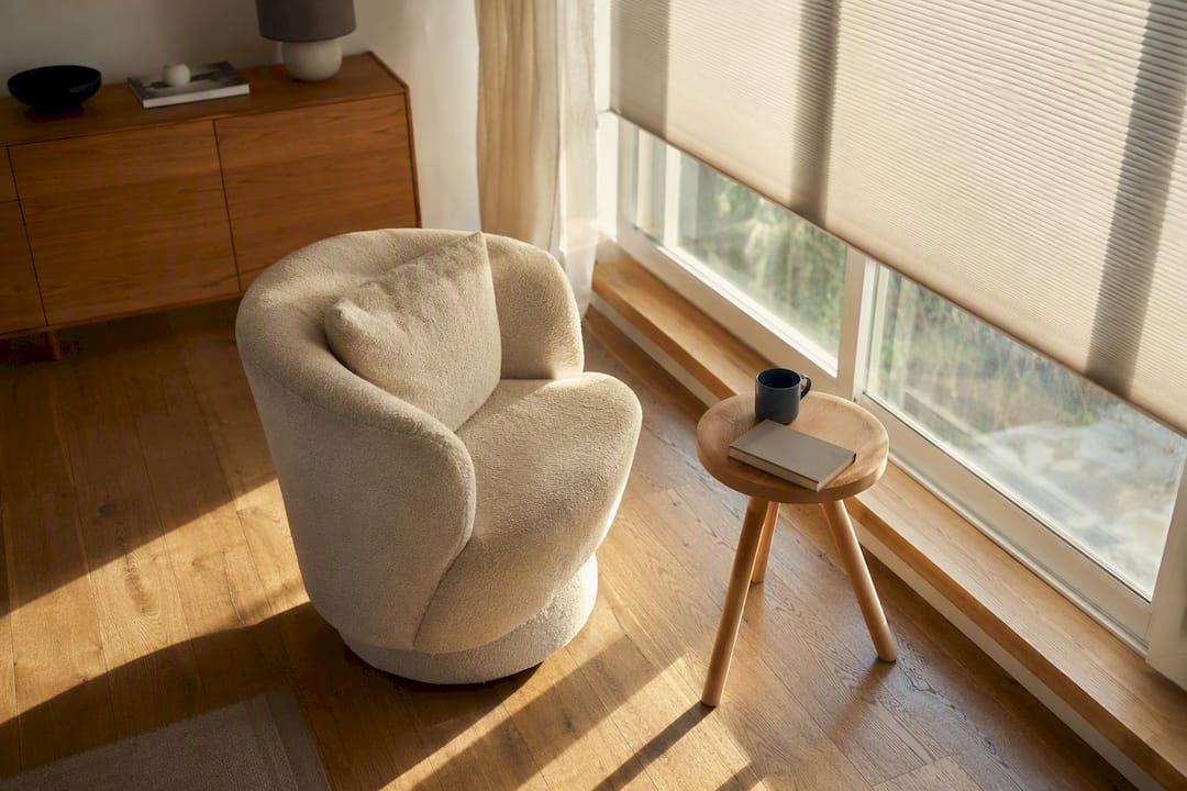 Ein drehbarer Holzsessel und ein Tisch im Sonnenlicht.