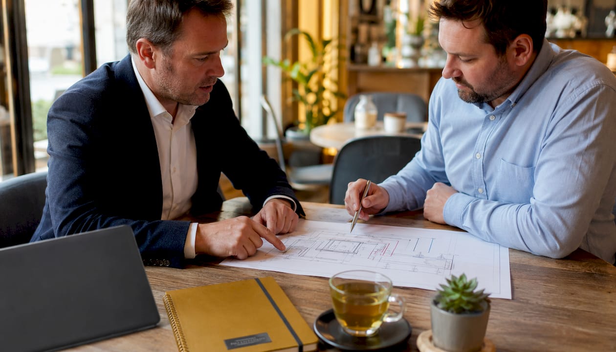 Hands and plans showing hybrid heating consultation