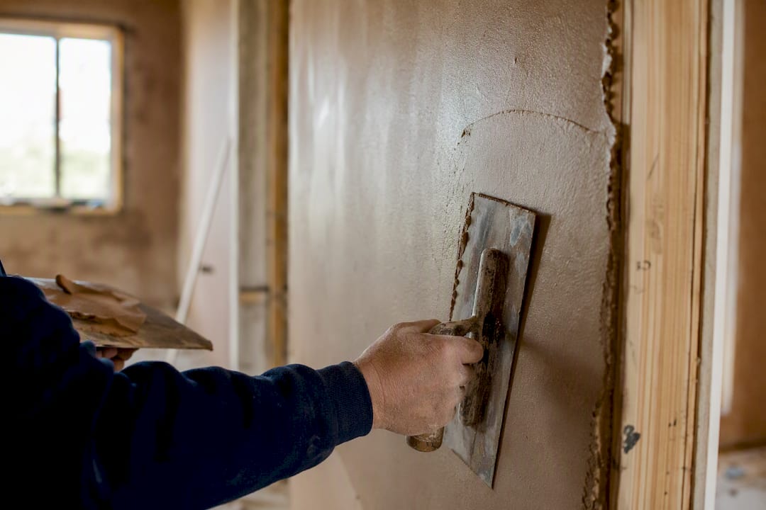 Close-up of worker plastering wall interior