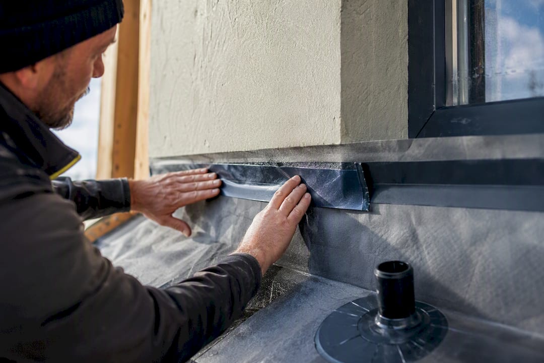 Worker sealing an extension membrane junction