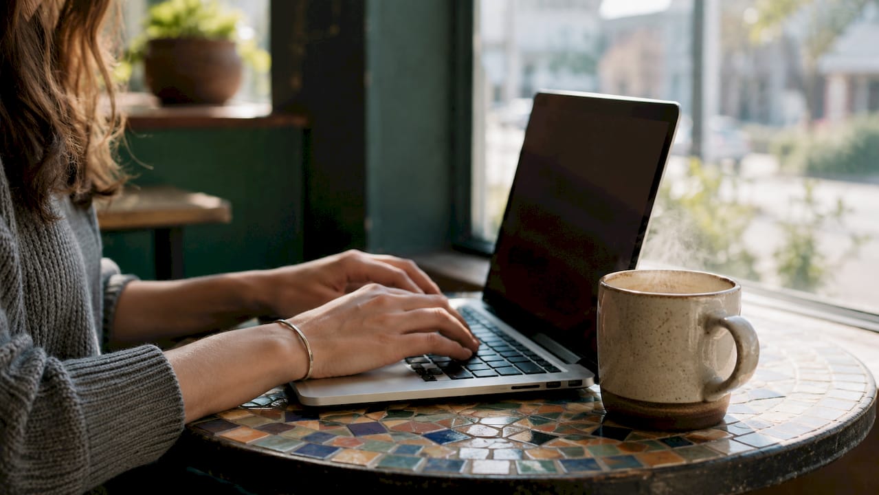 Hands typing tracking number on laptop keyboard