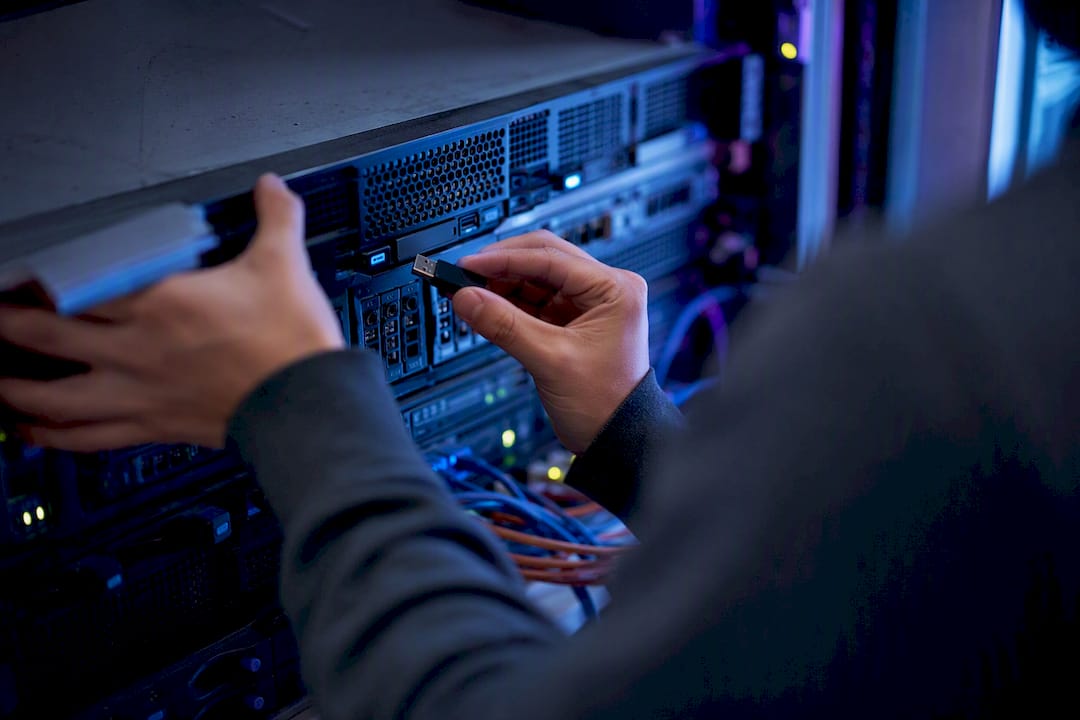 Hands holding USB security key near server