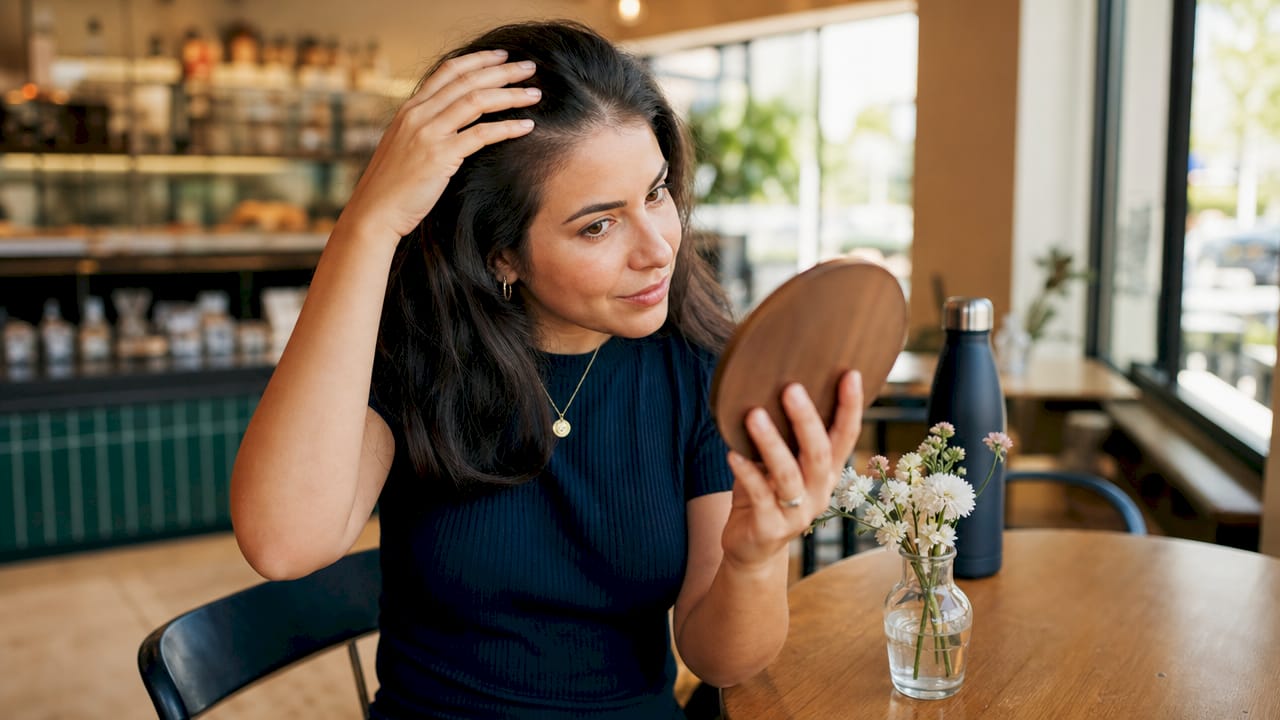 Woman checking new hair growth progress
