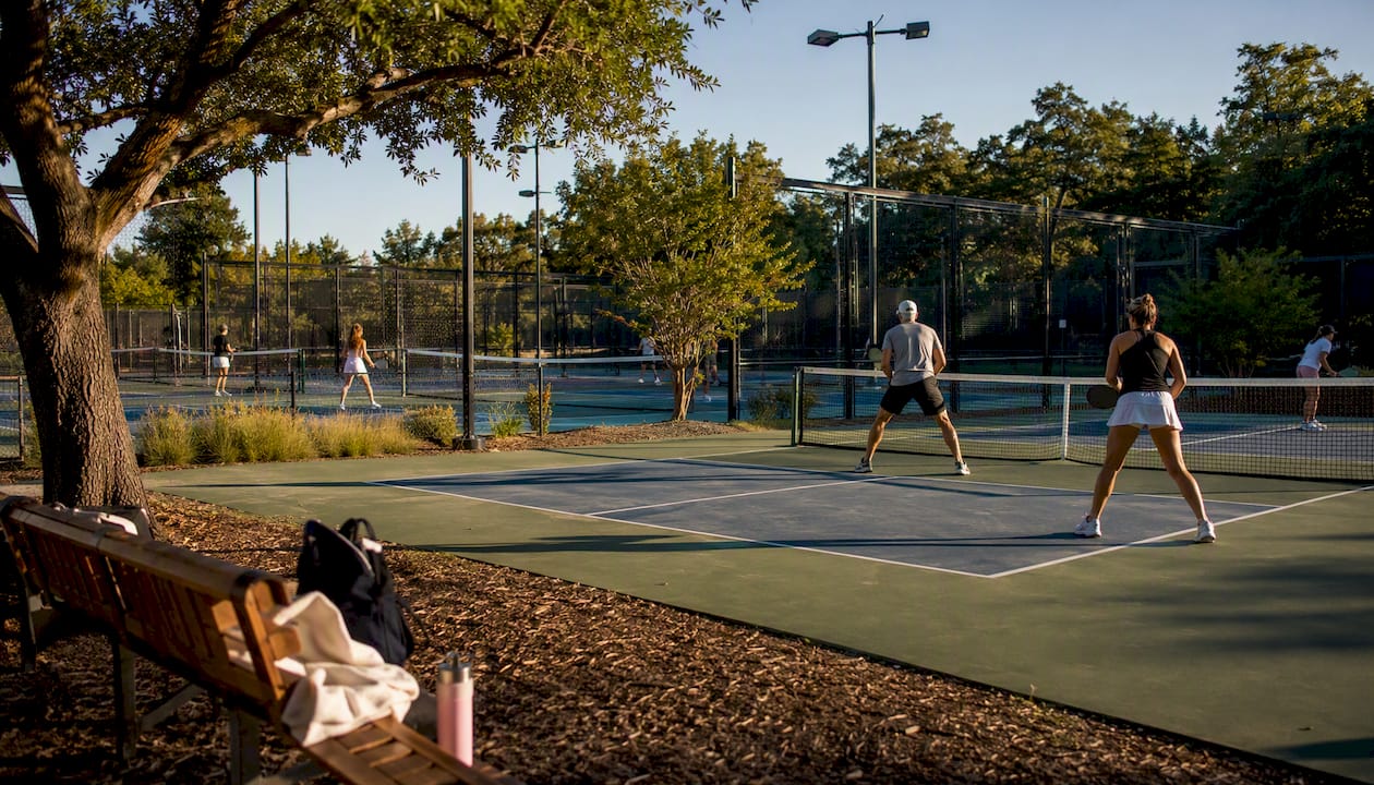 Multiple racquet sport courts in use outdoors