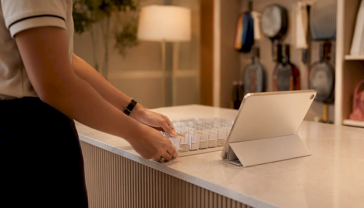 Staff hands arranging check-in badges and tablet