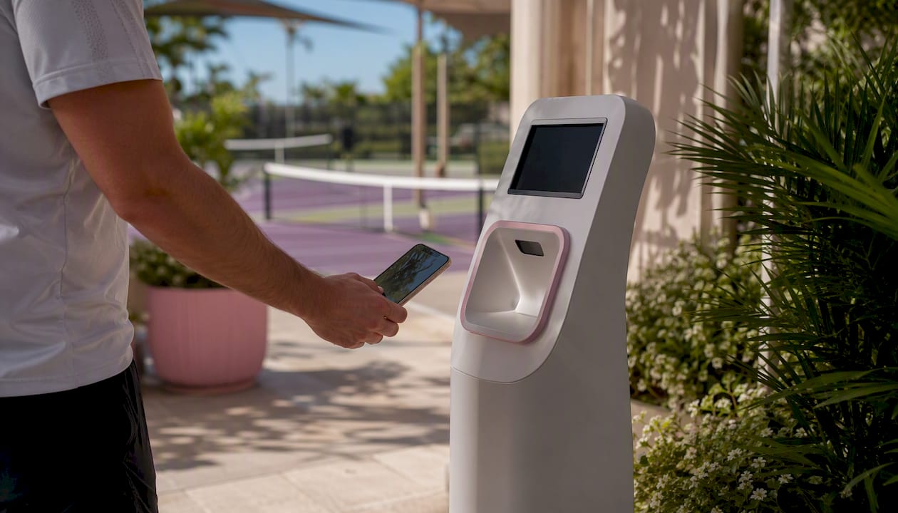 Player scanning QR code at racquet club kiosk