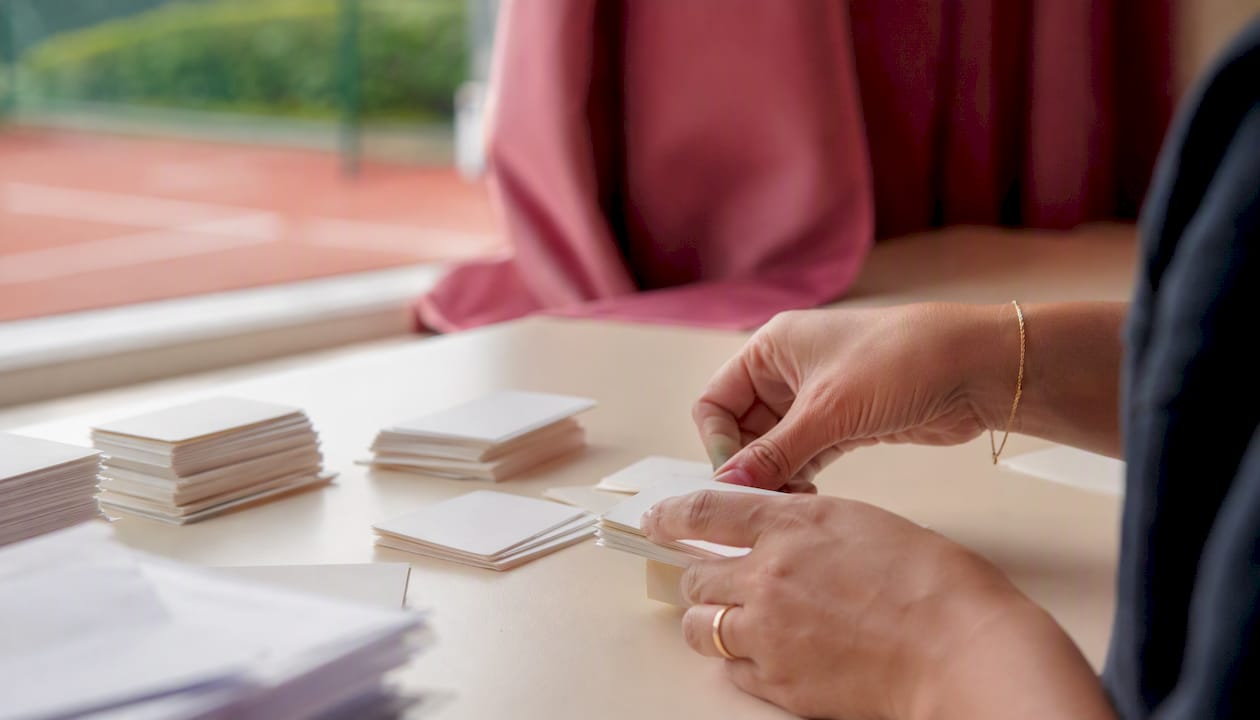 Hands organizing membership cards on desk